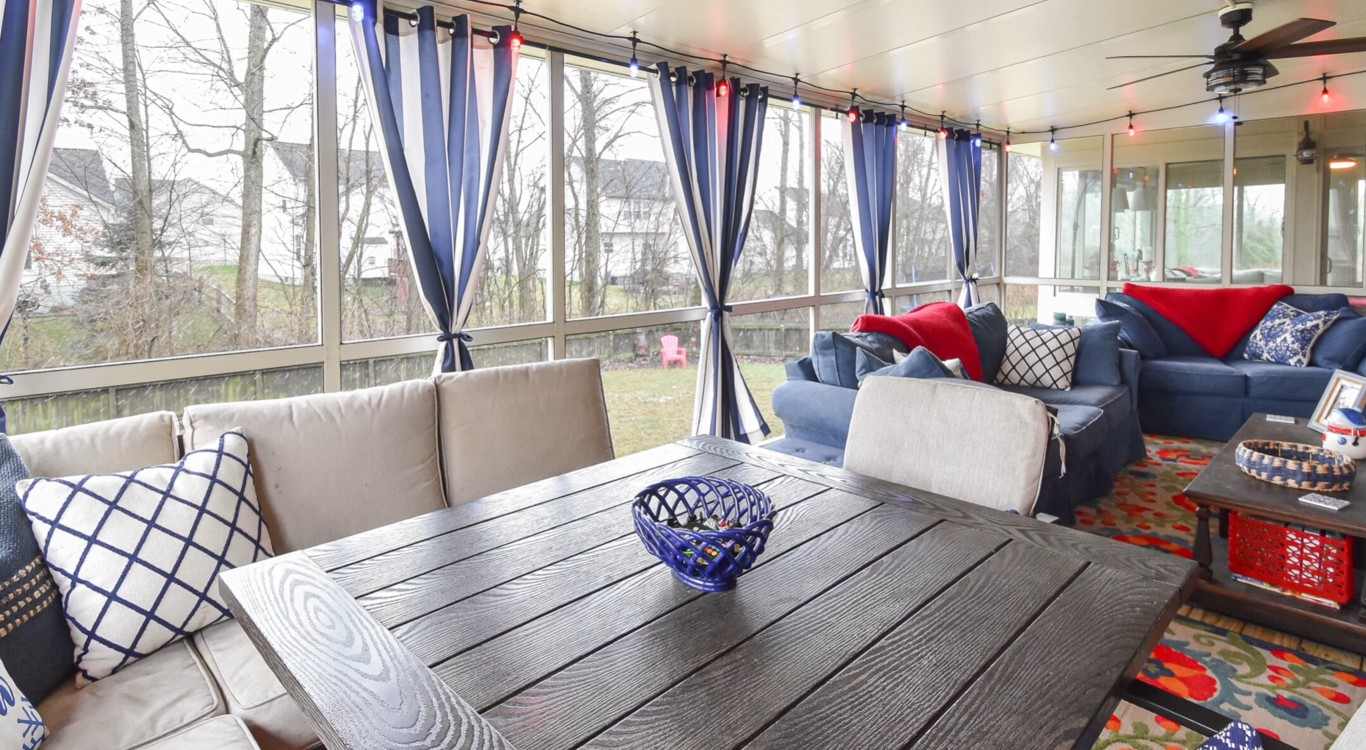 Three-season sunroom interior with comfortable seating and screened windows